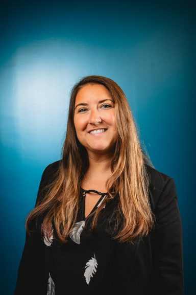 Headshot of a woman with a teal background