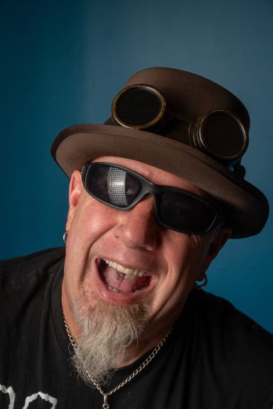 Head of a rock dude in sunglasses with brown top hat