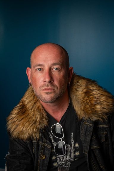 Headshot of a man with a blue background