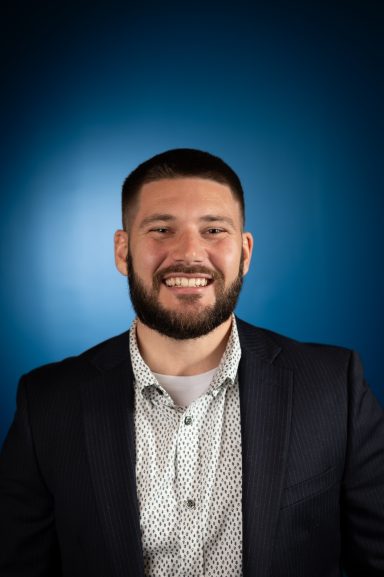 Headshot of a man with a blue background