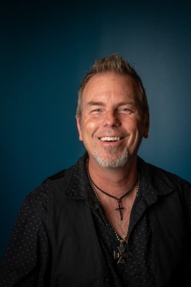 Headshot of a man with a blue background