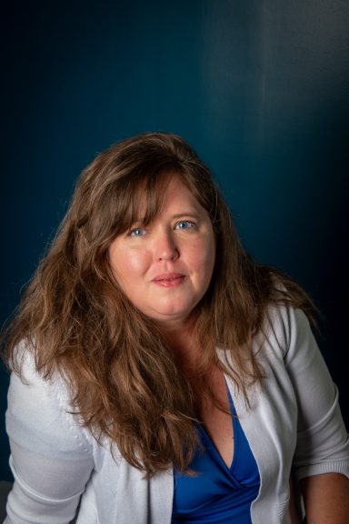 Headshot of a woman with a blue background